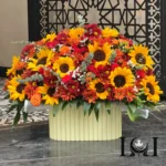 باکس گل BL110 شامل آفتابگردان، رز مینیاتوری نارنجی و داودی – ابعاد ارتفاع ۶۰ عرض ۵۰ سانتی‌متر – گل فروشی لونا فلاور کرج