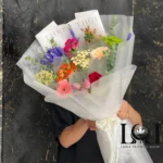 دسته گل ترکیبی DL142 شامل رز هلندی، ژربرا، مخلصه، ورونیکا، رز مینیاتوری و هیپو – ابعاد ارتفاع ۱۰۰ عرض ۶۰ سانتی‌متر – گل فروشی لونا فلاور کرج
