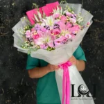دسته گل لیلیوم DL135 شامل لیلیوم اورینتال، رز مینیاتوری، لیسیانتوس، اوکالیپتوس و ورونیکا – ابعاد ارتفاع ۱۰۰ عرض ۷۰ سانتی‌متر – گل فروشی لونا فلاور کرج
